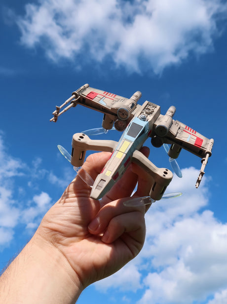 Star Wars Drone T65 X-Wing holdt i haanden mod blaa himmel